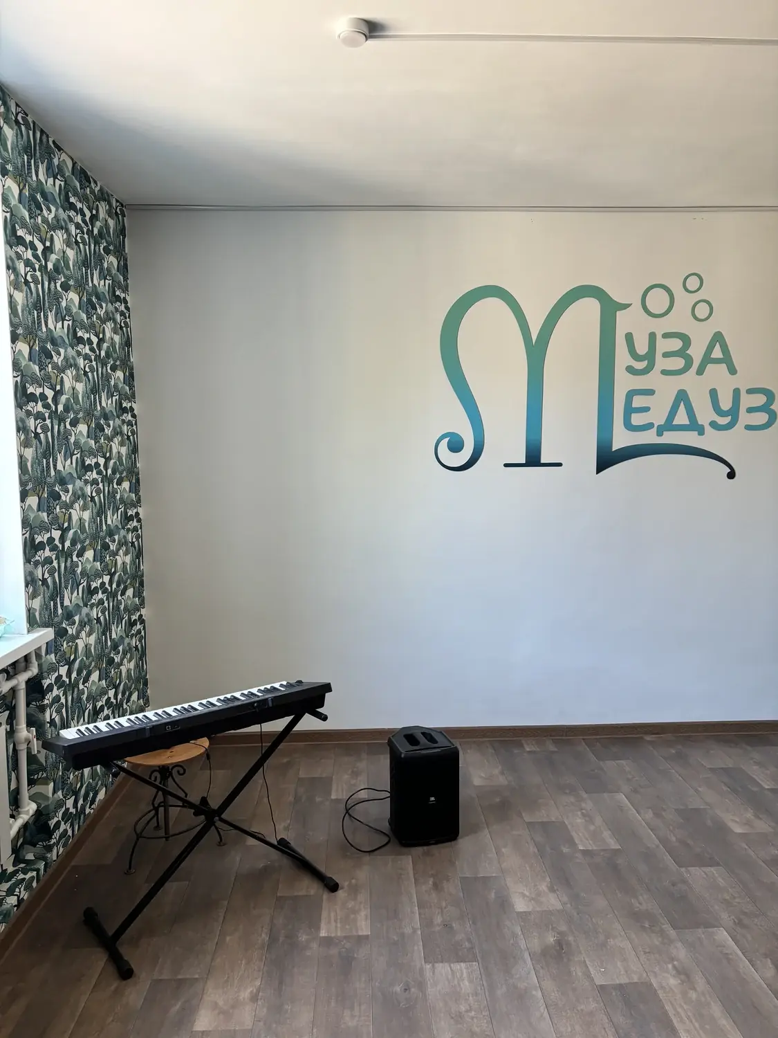 Класс школы «Муза Медуза» с фирменным логотипом на стене